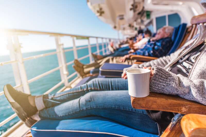 people lounging on cruise ship lounge chairs